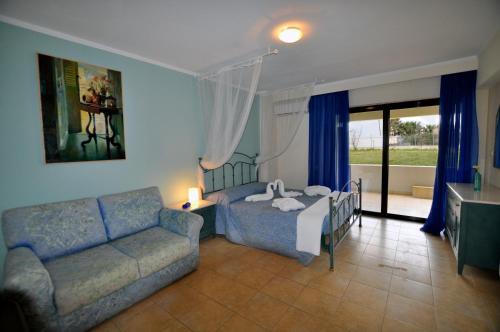 a bedroom with a bed and a couch at Luxury Xenos Villa 2 With 4 Bedrooms , Private Swimming Pool, Near The Sea in Tigaki