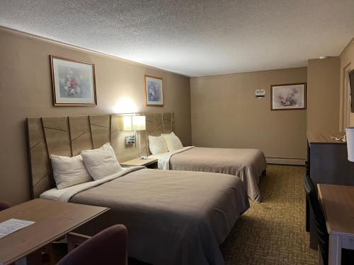 a hotel room with two beds and a table at Viking Arms Inn - Ludington in Ludington