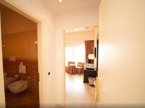 een badkamer met een bad, een toilet en een wastafel bij Hotel Santa Lucia Le Sabbie d'Oro in Cefalù