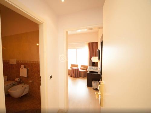 a bathroom with a tub and a toilet and a sink at Hotel Santa Lucia Le Sabbie d'Oro in Cefalù