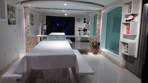 a dining room with a white table in a room at Perohouse in Cabo Frio