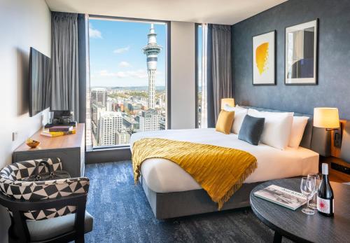 a hotel room with a large bed and a large window at voco Auckland City Centre by IHG in Auckland