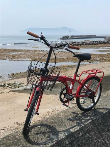 a red bike with a basket parked on the beach at Sinori205 in Hakodate