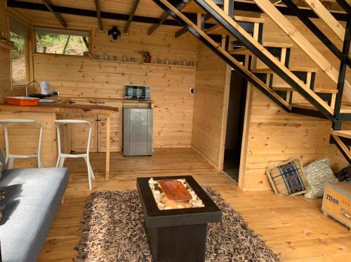 ein Wohnzimmer einer Holzhütte mit einer Küche in der Unterkunft Mirador Valeisa in Guatavita