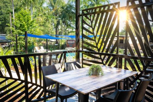 a wooden table and chairs on a deck at Oasis Tourist Park in Palmerston