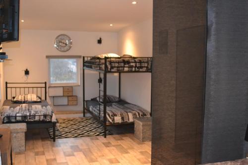 Cette chambre comprend 2 lits superposés et une horloge murale. dans l'établissement Maison d'hôtes A la fontaine fleurie 88, à Frémifontaine