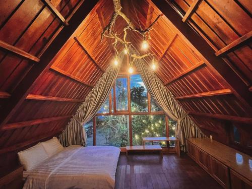 大叻的住宿－貝瑞瓦利山林小屋，一间带床的卧室,位于带窗户的房间内
