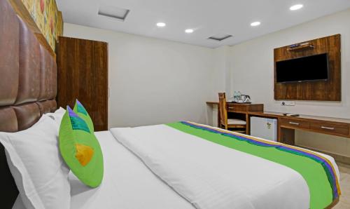 a bedroom with a white bed and a television at Treebo Mona Grand in New Delhi