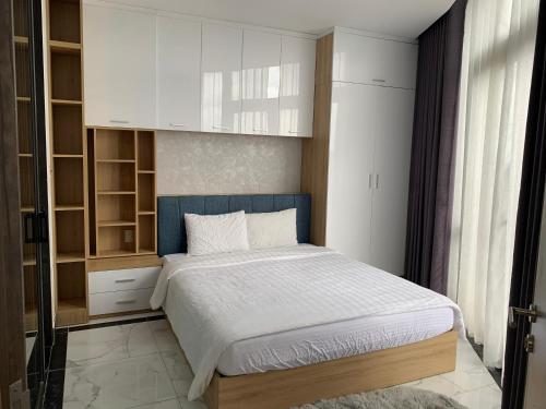 a bedroom with a bed with a blue headboard at CĂN HỘ PANORAMA ĐÀ LẠT 2 PHÒNG Ngủ in Xuan An