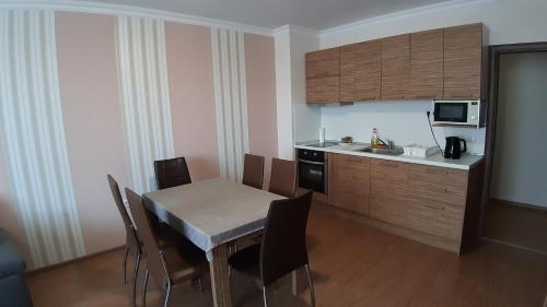 a kitchen and dining room with a table and chairs at Apartament Sarafovo in Burgas City