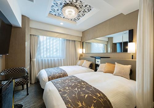 a hotel room with two beds and a mirror at APA Hotel Yodoyabashi Kitahama Ekimae in Osaka