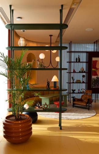 a living room with a green shelving unit at The Standard, Bangkok Mahanakhon in Bangkok