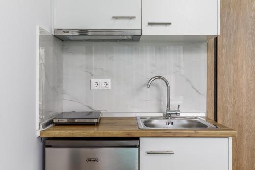 a kitchen with a sink and a stove at Anassa Suites in Leptokaria
