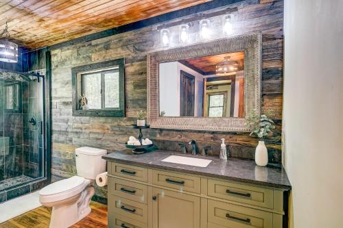 a bathroom with a sink and a toilet and a mirror at Rustic Oasis in Ellijay