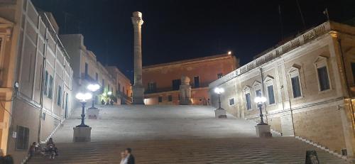 an empty street at night with a tower in the background at Il Porto Affittacamere b&b in Brindisi