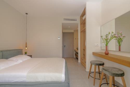 a bedroom with a bed and two stools at Green Herbs Villa in Kalamaki