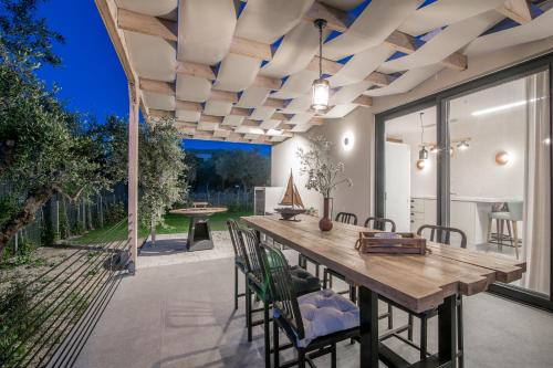 a dining room with a wooden table and chairs at Green Herbs Villa in Kalamaki