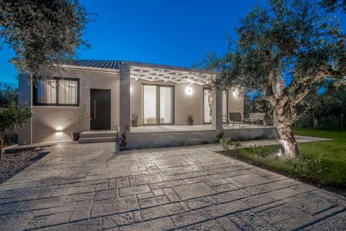 a house with a stone driveway in front of it at Green Herbs Villa in Kalamaki