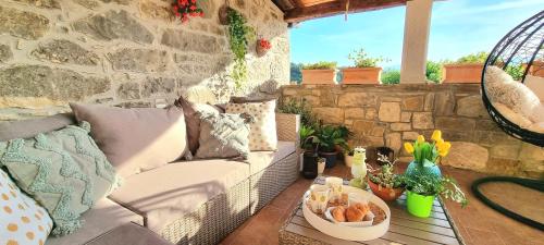 a patio with a couch and a table on a stone wall at Apartment HUM-the smallest town in the world in Hum