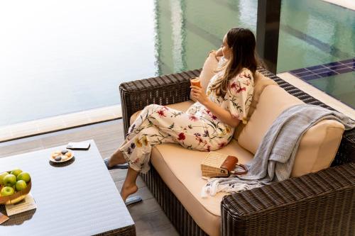 a woman sitting on a couch talking on a cell phone at Ibis Jeddah Malik Road in Jeddah