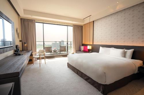 a hotel room with a large bed and a desk at Crowne Plaza Tainan by IHG in Tainan