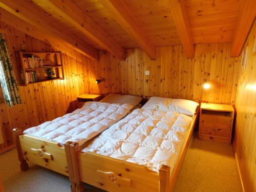 a bedroom with a bed in a wooden room at Ferienwohnung Traumzeit OG/DG in Bellwald