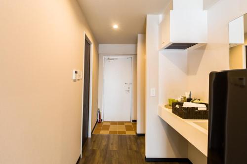 a kitchen with a hallway leading to a door at ミチ旅ホテル 読谷 in Yomitan