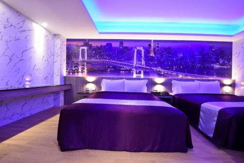 two beds in a room with a view of a city at W3 MOTEL in Luzhu