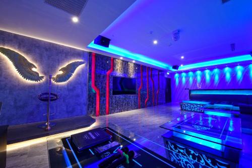 a nightclub with purple and green lighting and wings on the wall at W3 MOTEL in Luzhu