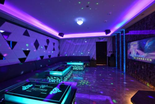 a purple room with a couch and a tv at W3 MOTEL in Luzhu