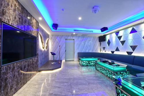 a living room with a blue couch and a tv at W3 MOTEL in Luzhu