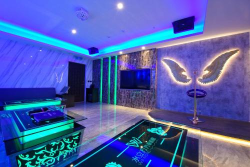 a room with a video game console and wings on the wall at W3 MOTEL in Luzhu