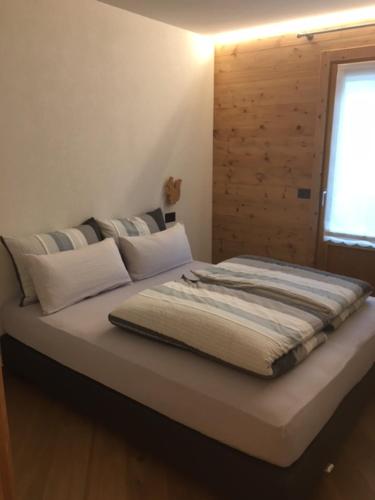- un lit dans une chambre avec fenêtre dans l'établissement Chrys appartamenti, à Valfurva