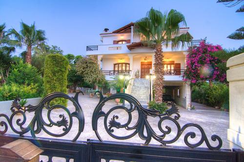 a house with a black iron fence in front of it at Villa Elena Crete in Viranepiskopí