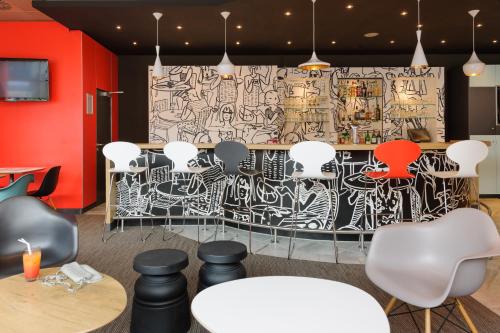 a room with chairs and a wall covered in graffiti at ibis Luebeck City in Lübeck