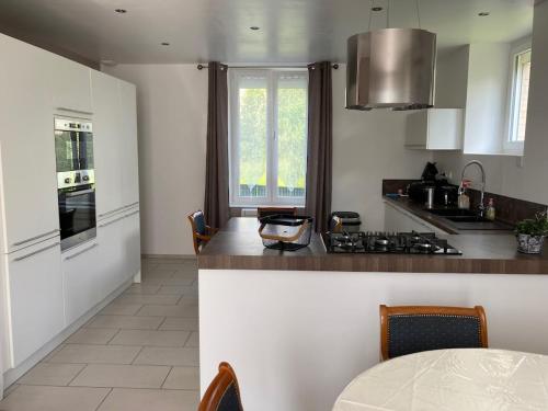 a kitchen with a stove and a counter top at Gite Chez Livia Hautes Vosges in Bruyères