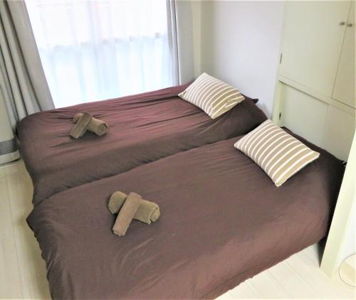 2 camas en un dormitorio pequeño con 2 almohadas en 札幌市中心部大通公園まで徒歩八分観光移動に便利なロケーションs1 202, en Sapporo