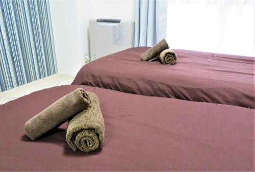 2 camas con toallas en una habitación en 札幌市中心部大通公園まで徒歩八分観光移動に便利なロケーションs1 202, en Sapporo
