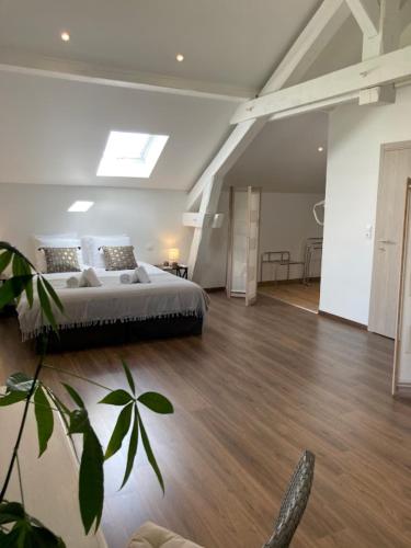 une chambre avec un grand lit dans une pièce avec parquet dans l'établissement Gite Chez Livia Hautes Vosges, à Bruyères