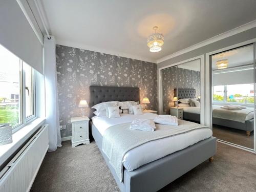 a bedroom with a bed and a large window at Dragonfly - HOT TUB luxury two bedroom cottage in Cellardyke