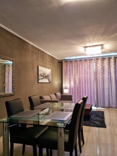 a dining room with a table and a couch at Island Club by Smart City Stays in Cape Town