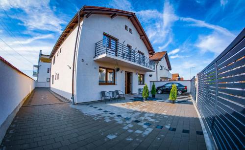 uma casa branca com um carro estacionado numa garagem em Five House em Sibiu