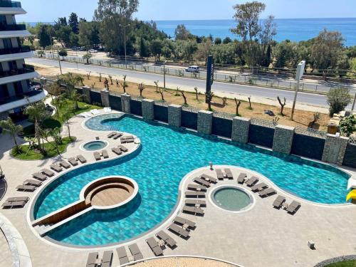 a pool with chaise lounge chairs in a resort at Via Mar Residence - Alanya Experience in Alanya
