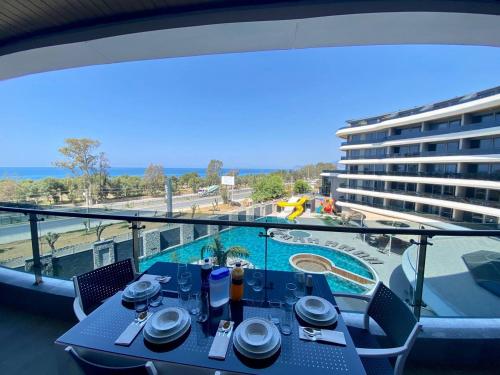 a table on a balcony with a view of a pool at Via Mar Residence - Alanya Experience in Alanya