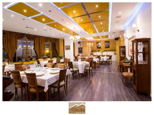 een eetkamer met tafels en stoelen in een restaurant bij Hotel Dardha in Dardhë