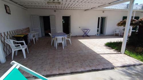a patio with white chairs and tables and a table at La Dea del Mare in Ischia