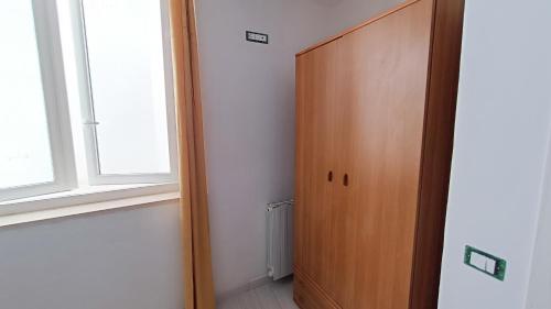 a hallway with a wooden door and a window at La Dea del Mare in Ischia
