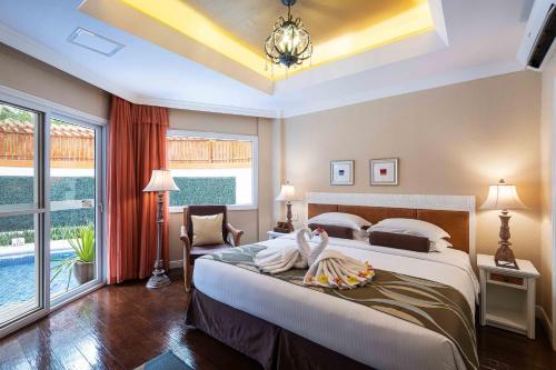 a bedroom with a large bed and a large window at Jpark Island Resort & Waterpark Cebu in Mactan