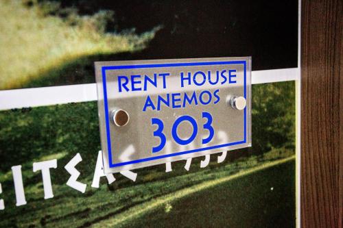 a sign on a fence that says rent house arrows at RENT HOUSE ANEMOS in Iraklitsa