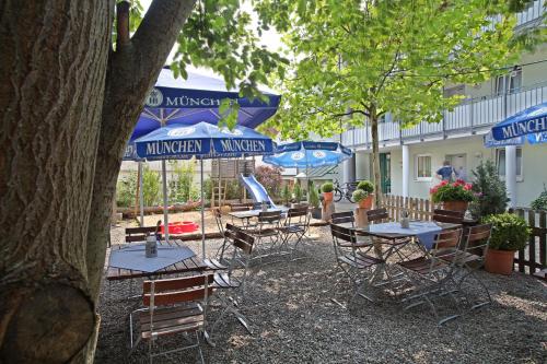 a group of tables and chairs with umbrellas at Hotel Gasthof Traubenbräu in Krumbach